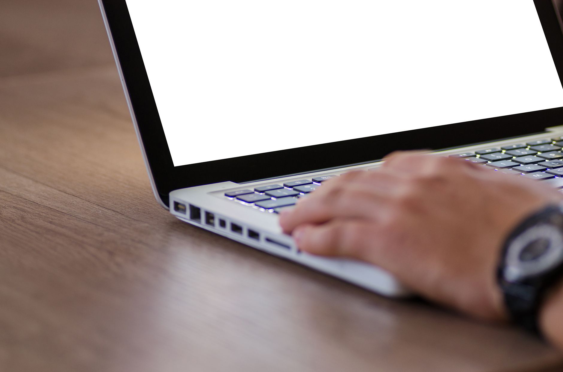 Osoba pracująca na laptopie z białym ekranem na drewnianym biurku