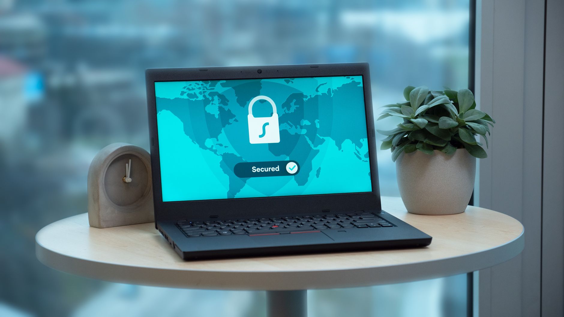 Laptop na biurku wyświetlający ekran zabezpieczenia z ikoną kłódki i napisem Secured